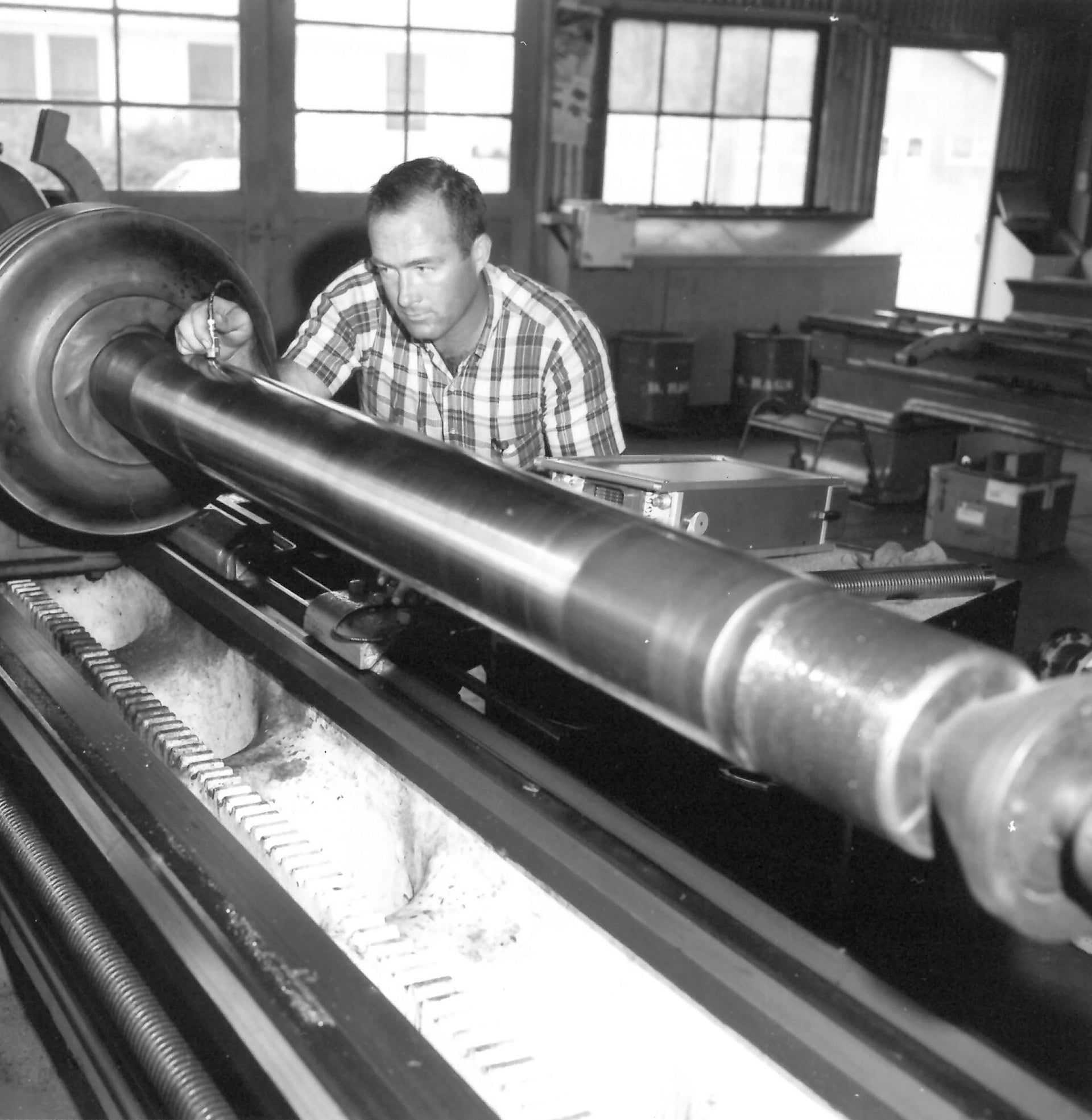 Old photo of a man working on a pipe